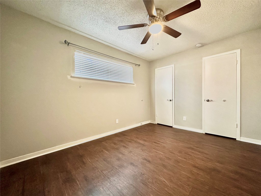 1200 Banister Lane, Unit 5 Austin, TX 78704 - Photo 10 of 13 an empty room with wooden floor and ceiling fan
