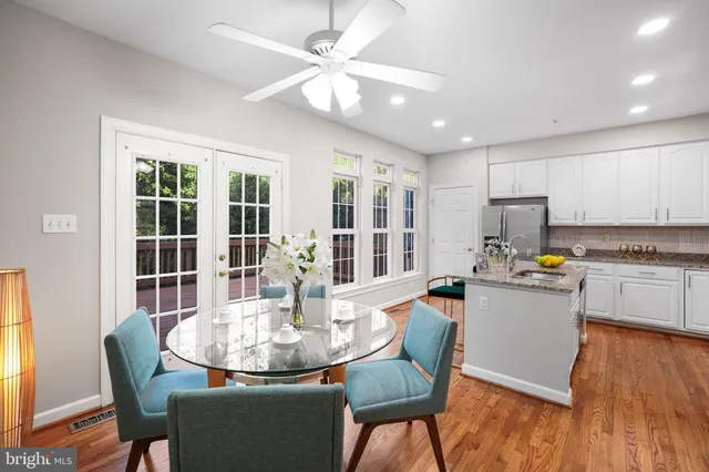 a kitchen with a dining table chairs and refrigerator