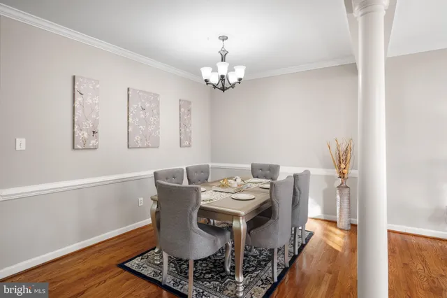 a view of a dining room with furniture a chandelier and wooden floor