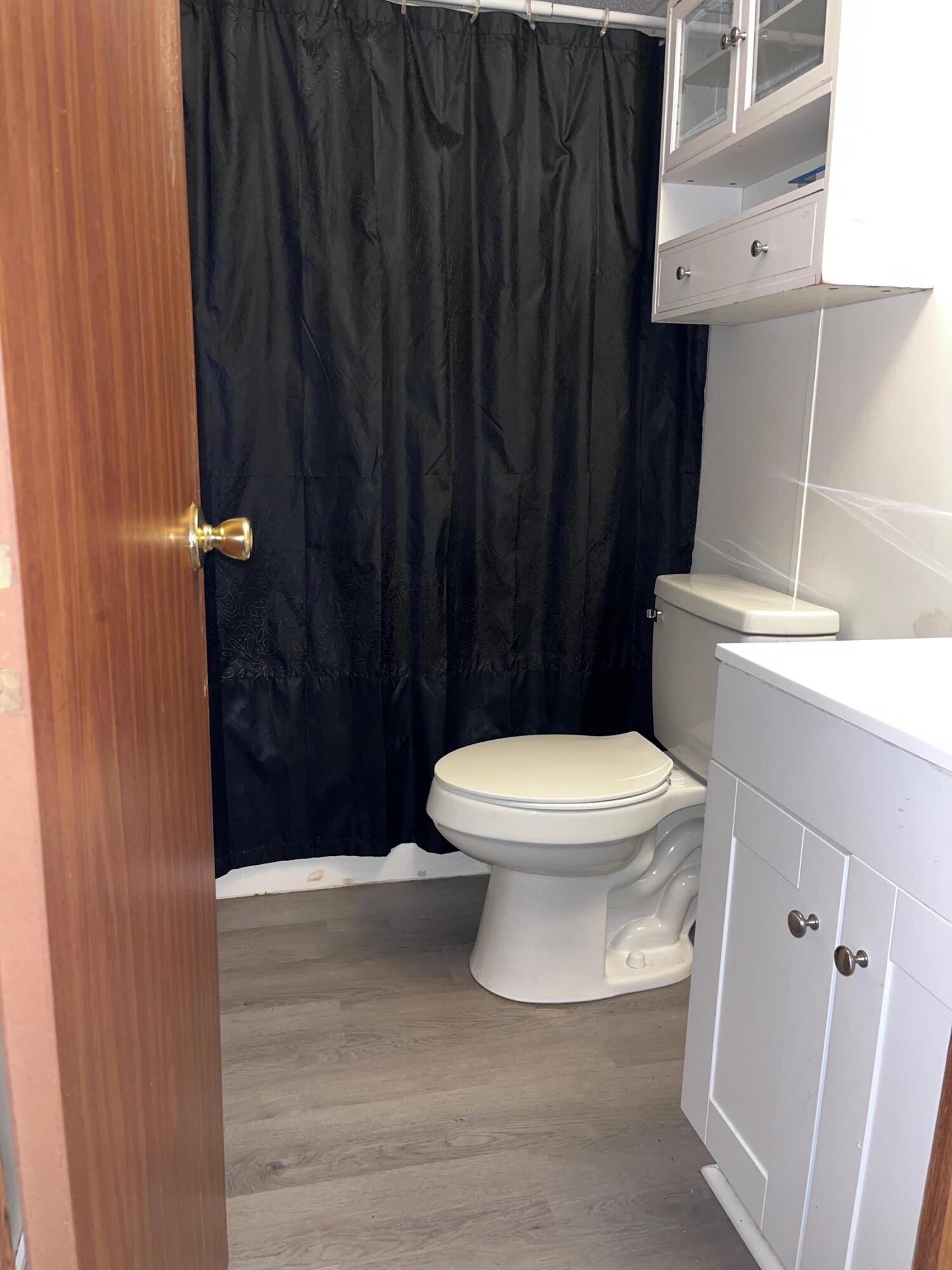 1923 Redwood Road Southeast Roanoke, VA 24014 - Photo 30 of 31 a white toilet sitting next to a shower curtain