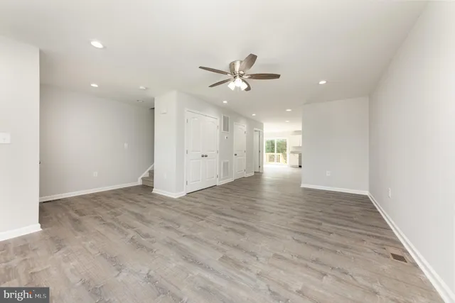 wooden floor in an empty room with a ceiling fan