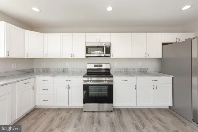 a kitchen with granite countertop white cabinets and white appliances