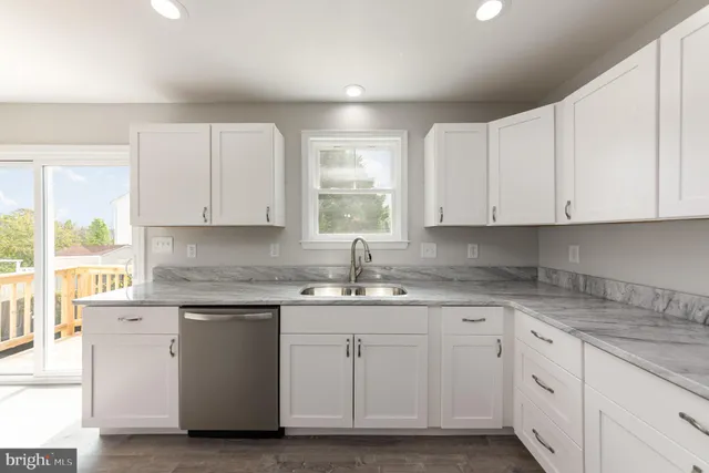 a kitchen with white cabinets white appliances and sink