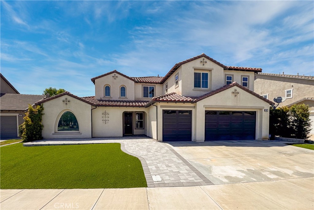 14977 Brooktree Street Eastvale, CA 92880 - Photo 2 of 34 a front view of a house with a yard and garage