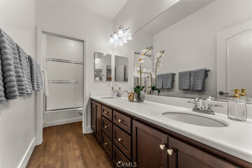14977 Brooktree Street Eastvale, CA 92880 - Photo 19 of 34 a spacious bathroom with a double vanity sink a mirror and a shower