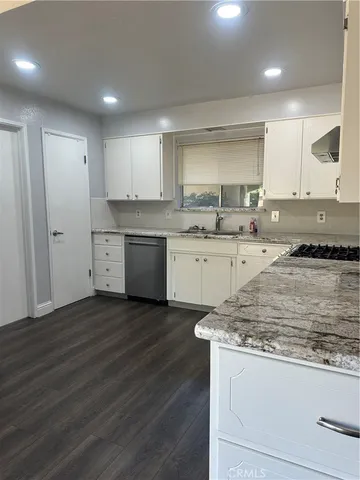 a kitchen with granite countertop a sink and cabinets