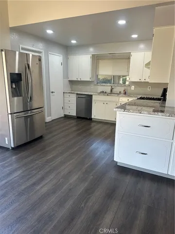 a kitchen with a refrigerator sink and cabinets