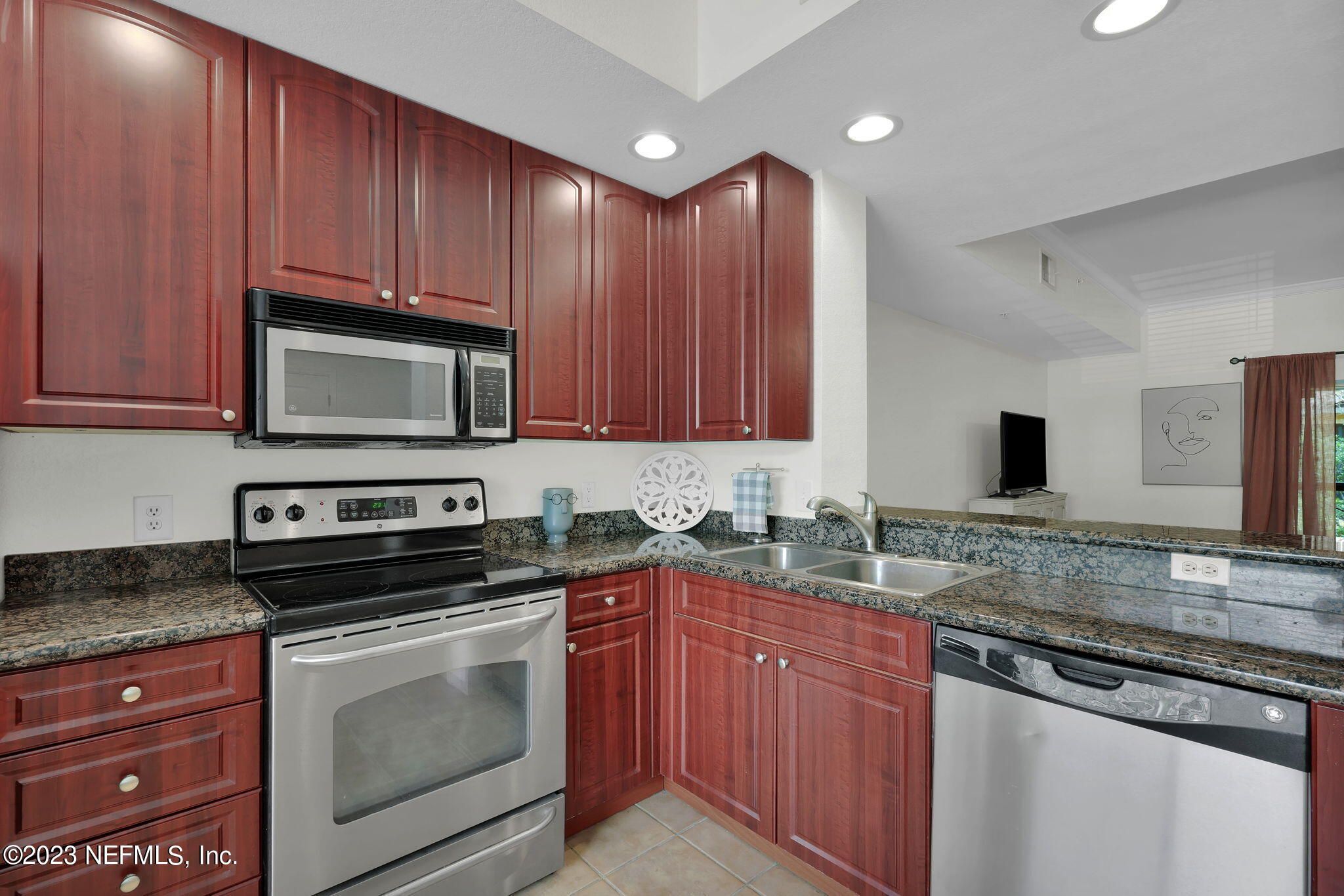 9745 Touchton Road, Unit 428 Jacksonville, FL 32246 - Photo 12 of 40 a kitchen with stainless steel appliances granite countertop wooden cabinets and a stove top oven