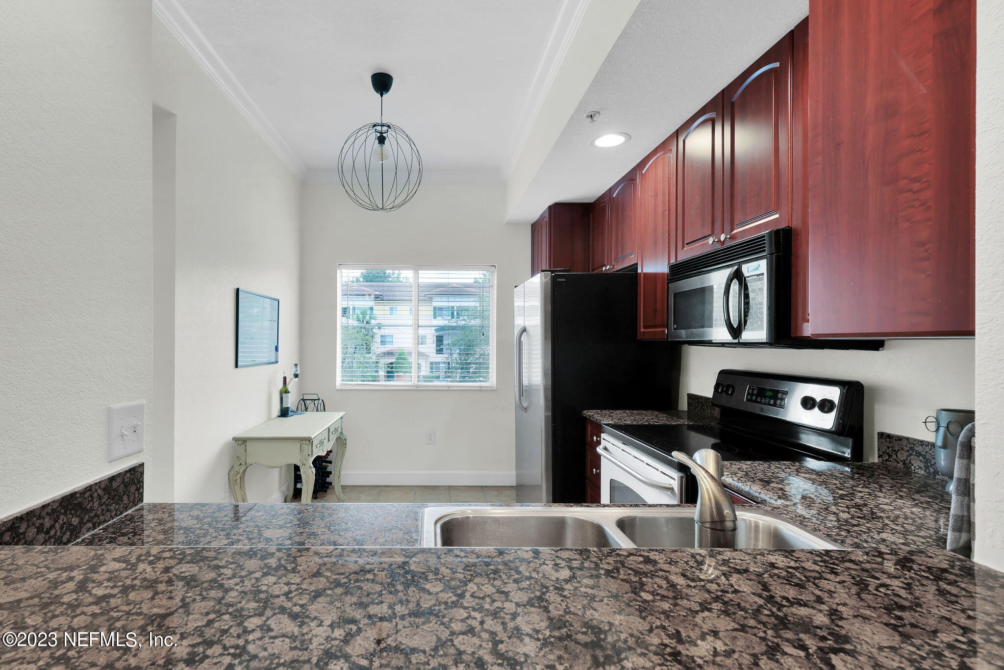 9745 Touchton Road, Unit 428 Jacksonville, FL 32246 - Photo 13 of 40 a kitchen with stainless steel appliances granite countertop a sink refrigerator stove and microwave