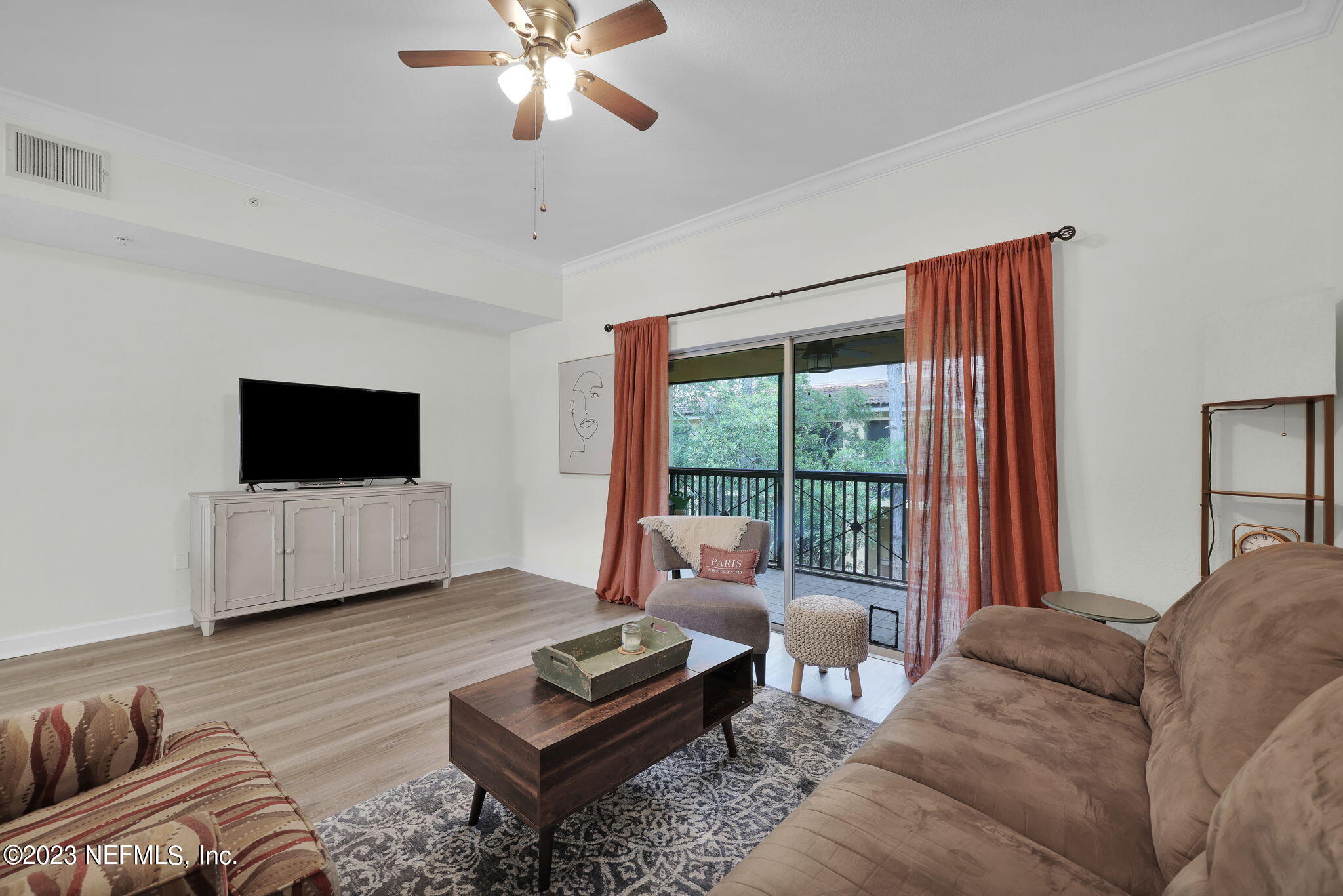 9745 Touchton Road, Unit 428 Jacksonville, FL 32246 - Photo 17 of 40 a living room with furniture a flat screen tv and a large window