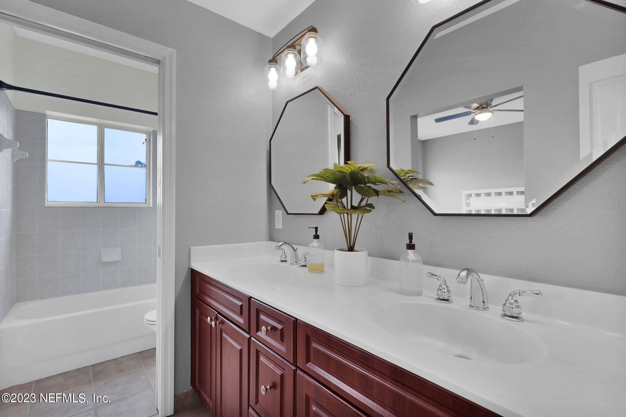 9745 Touchton Road, Unit 428 Jacksonville, FL 32246 - Photo 28 of 40 a bathroom with a double vanity sink and a mirror