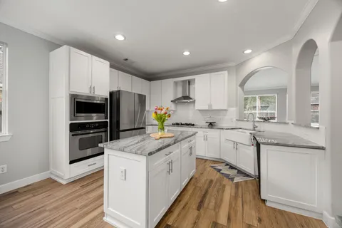 a kitchen with white cabinets and stainless steel appliances
