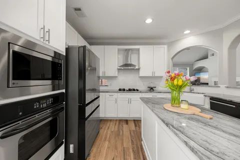 a kitchen with kitchen island stainless steel appliances and wooden cabinets