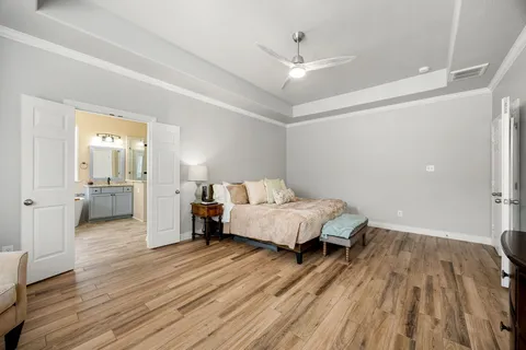 a spacious bedroom with a bed and wooden floor