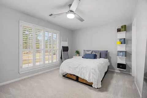 a large bed sitting in a bedroom next to a window