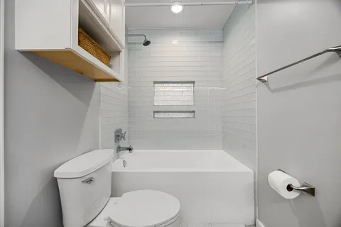 a bathroom with a toilet and a bath tub