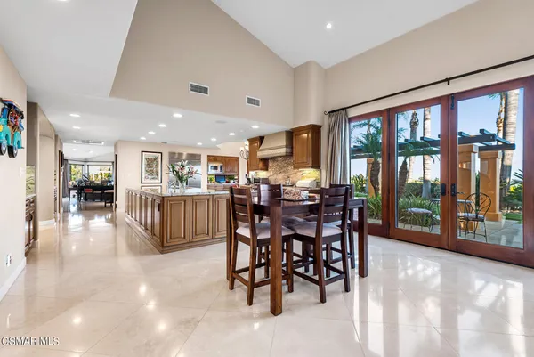 a view of a dining room and livingroom with furniture large windows a chandelier