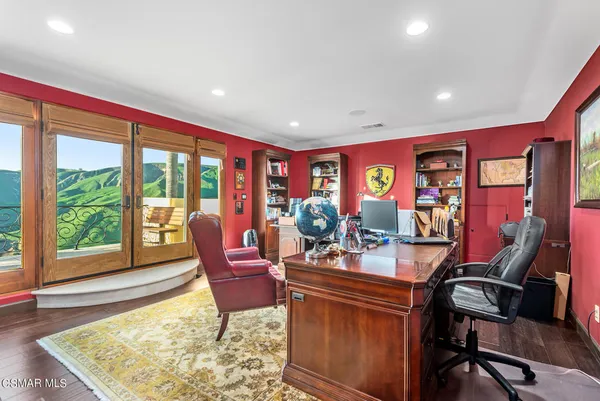 a spacious bedroom with a bed a couch and wooden floor