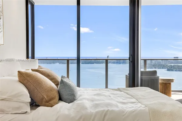 a bedroom with a bed and a large window