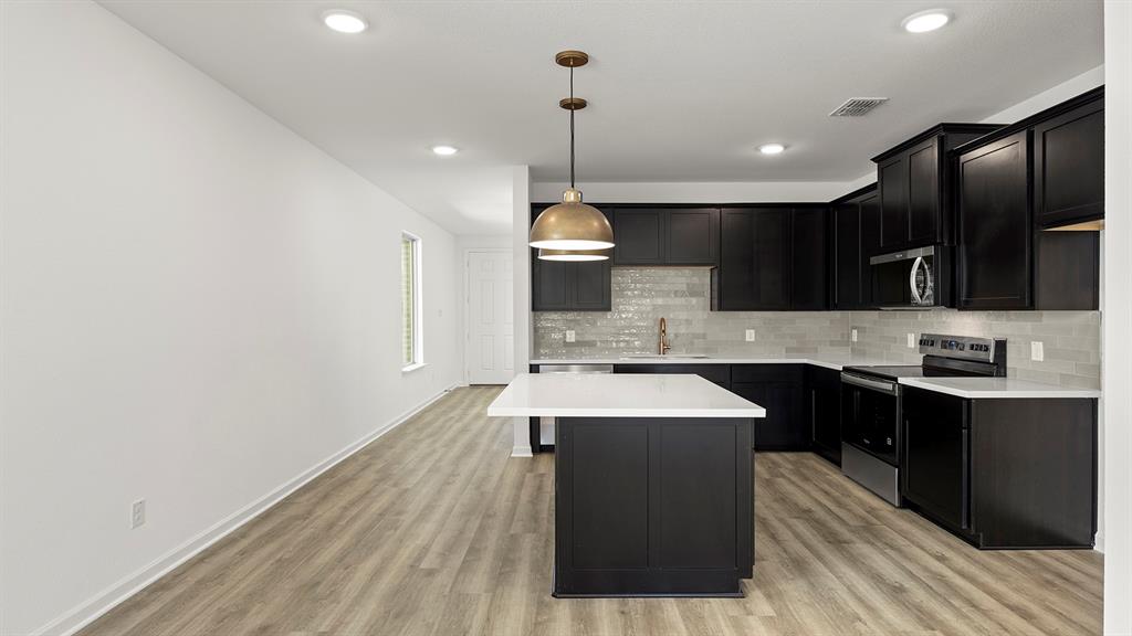 2516 YO Rnch Road Anna, TX 75409 - Photo 4 of 30 a kitchen with kitchen island a sink stainless steel appliances and cabinets