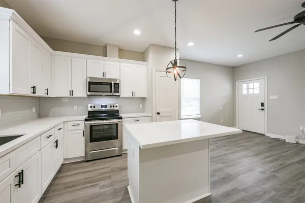 a view of a kitchen with a sink and refrigerator
