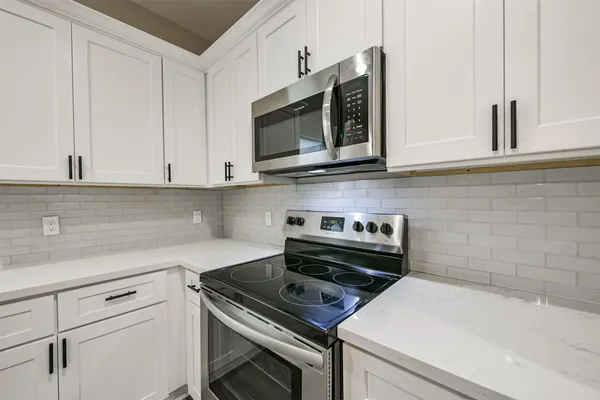 a large kitchen with cabinets wooden floor and stainless steel appliances