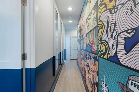 a bedroom with a bed and painting on the wall