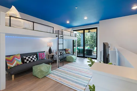 a living room with furniture a flat screen tv and a floor to ceiling window