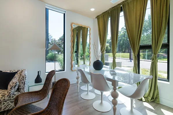 a dining room with furniture and large windows