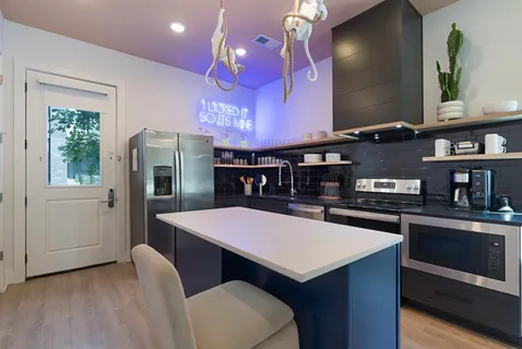 a kitchen with a stove a refrigerator and a dining table