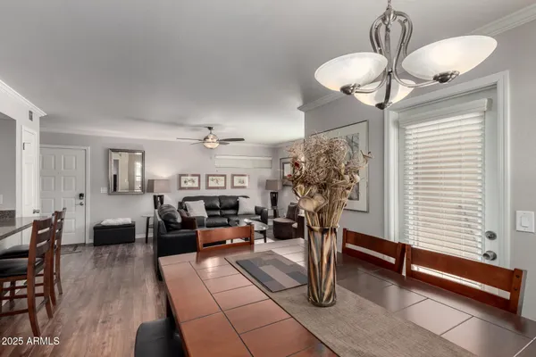 a living room with couches chandelier and a window