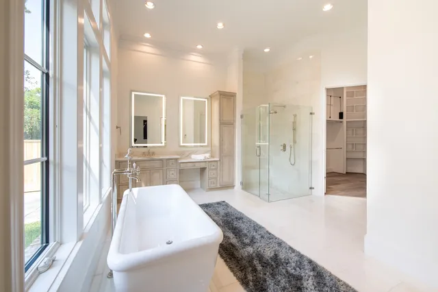 a bathroom with a bathtub shower sink and mirror
