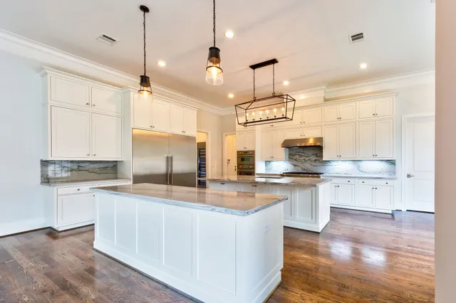 a large kitchen with cabinets wooden floor and stainless steel appliances
