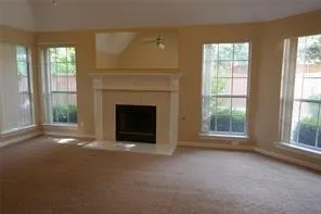 a view of a hallway with stainless steel appliances granite countertop a sink and a refrigerator