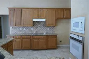 a kitchen with stainless steel appliances granite countertop a sink a stove and a microwave