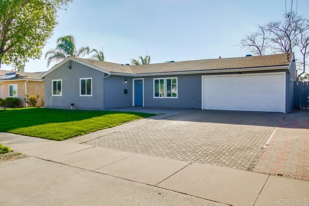 a view of a house with a yard and large tree