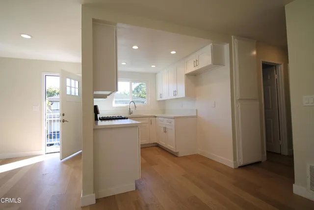 a kitchen with a refrigerator and a stove top oven