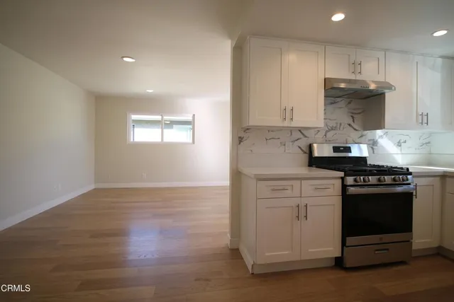 a kitchen with a stove and white cabinets