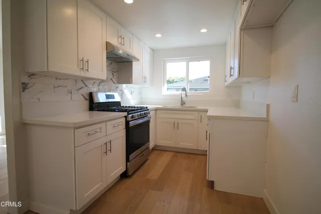 a kitchen with white cabinets stainless steel appliances and sink