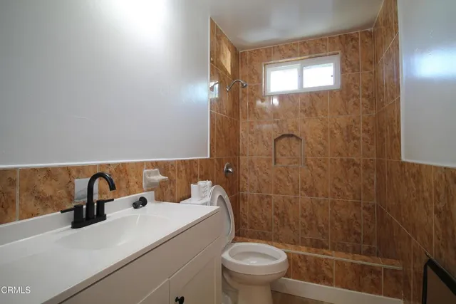 a bathroom with a sink a toilet and shower