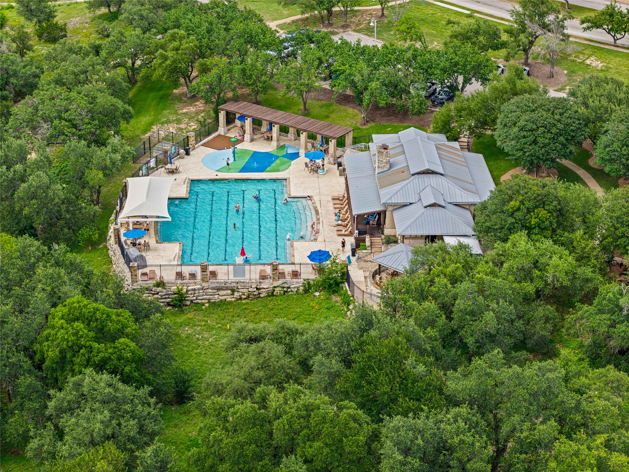 10700 Pointe View Drive Austin, TX 78738 - Photo 33 of 35 An aerial perspective reveals a vibrant community pool area nestled amongst lush green trees.