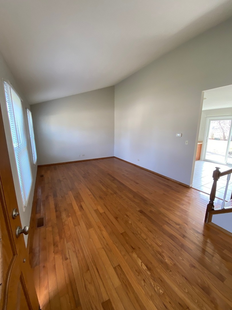 420 Iverson Lane Schaumburg, IL 60169 - Photo 3 of 12 wooden floor in an empty room with a window