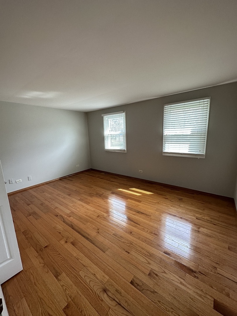 420 Iverson Lane Schaumburg, IL 60169 - Photo 7 of 12 an empty room with wooden floor and windows