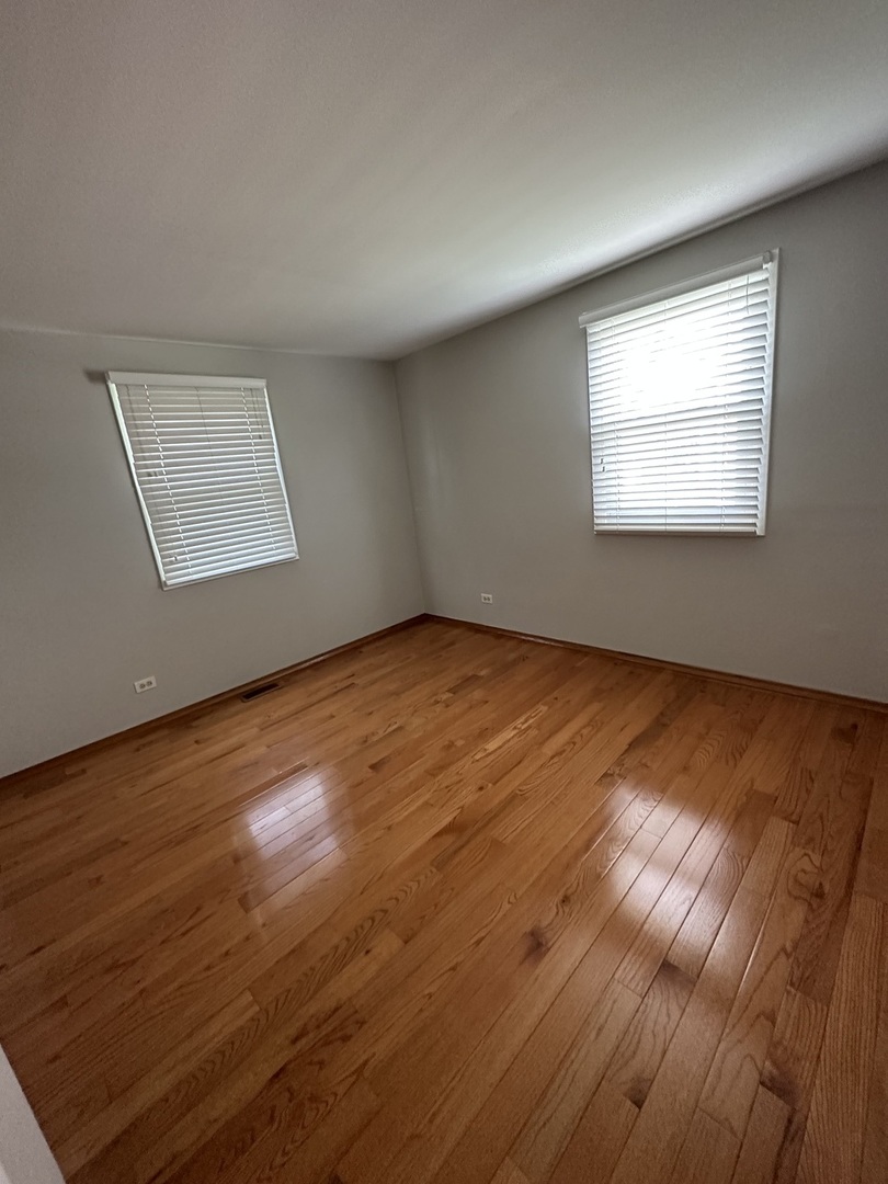 420 Iverson Lane Schaumburg, IL 60169 - Photo 10 of 12 a view of an empty room with wooden floor and a window