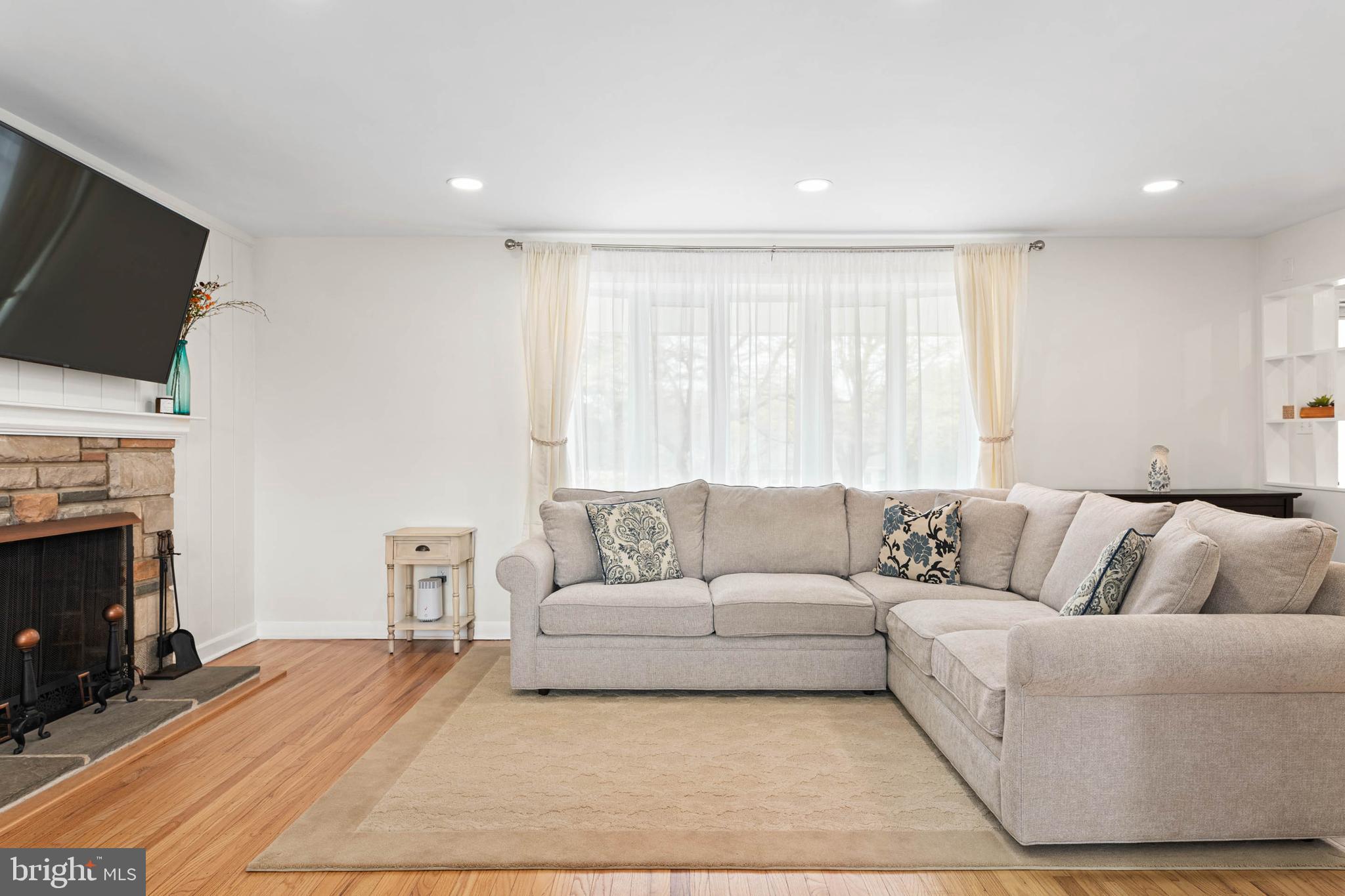 136 Ashley Road Newtown Square, PA 19073 - Photo 4 of 29 a living room with furniture a flat screen tv and a fireplace