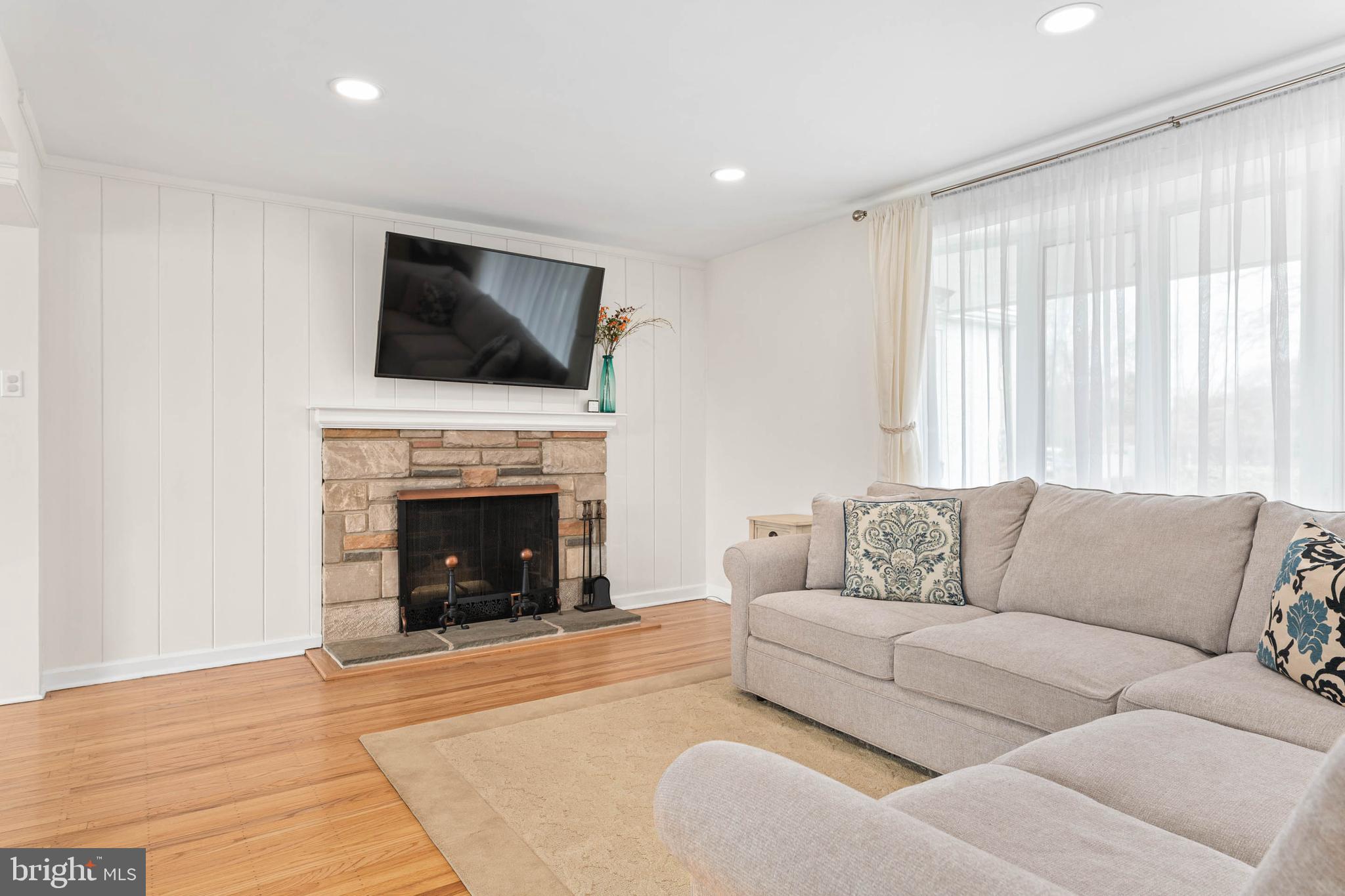136 Ashley Road Newtown Square, PA 19073 - Photo 5 of 29 a living room with furniture a flat screen tv and a fireplace