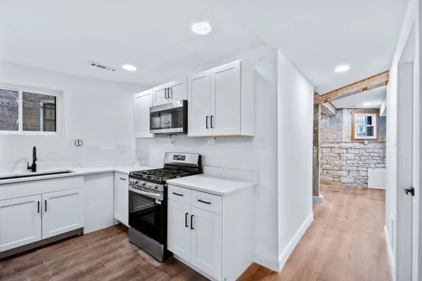 a kitchen with stainless steel appliances a sink stove and cabinets