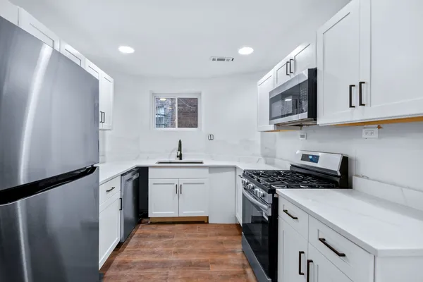 a kitchen with stainless steel appliances granite countertop a stove a sink and a refrigerator