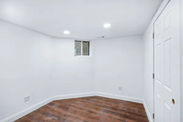 a view of empty room with wooden floor