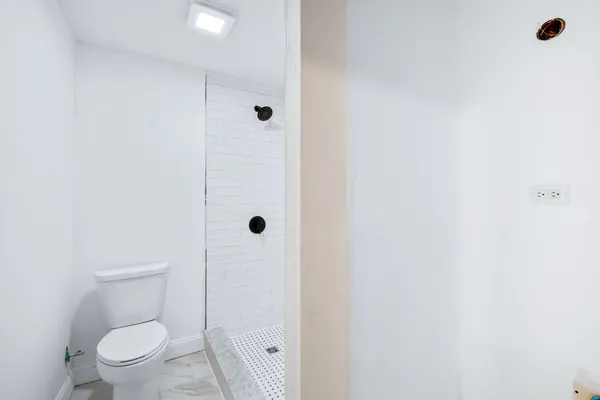 a bathroom with a toilet and a shower